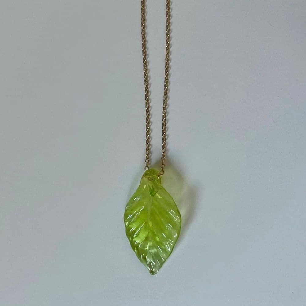 A glass leaf pendant on a necklace